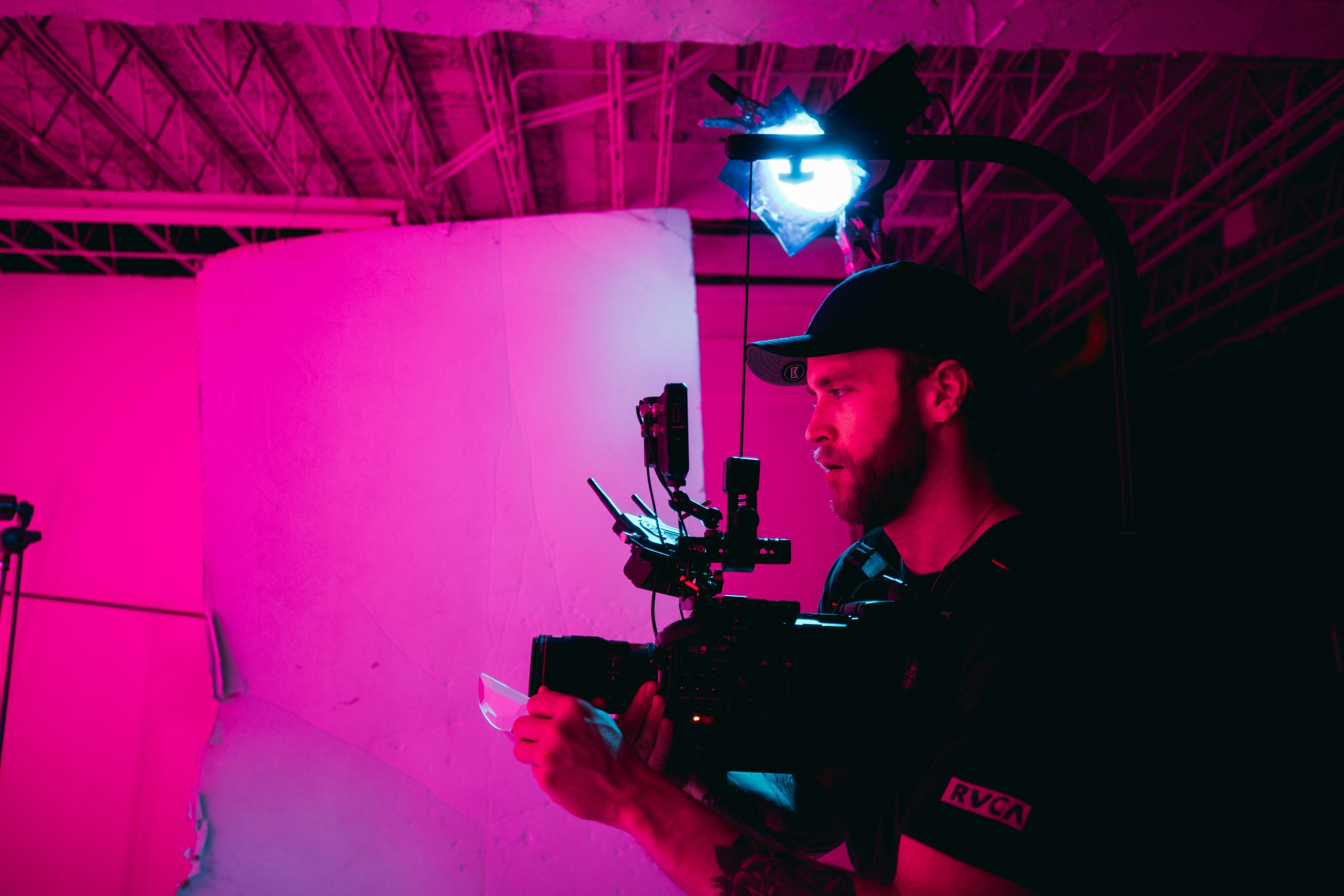 man in black polo shirt holding black video camera